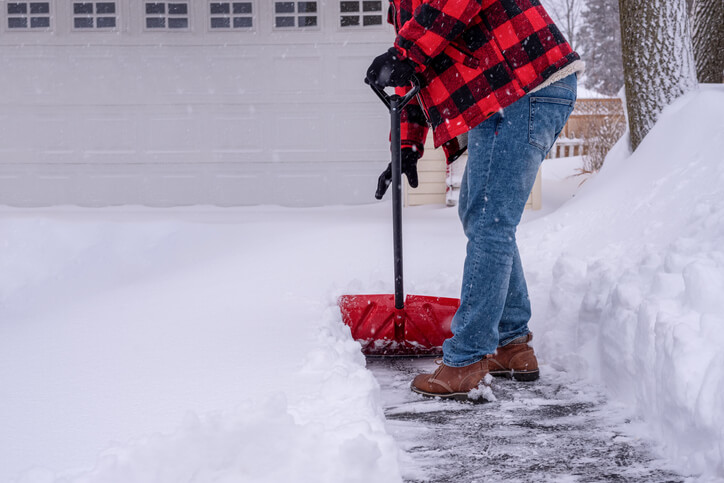 Man shoveling the driveway after a heavy snowfall