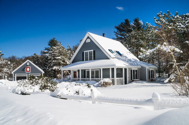 A small home and garage are covered with a fresh coating of snow during a Cape Cod Winter.